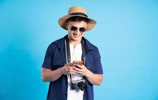 travel asian man portrait, isolated on blue background photo