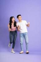 full body image of asian couple posing on purple background photo