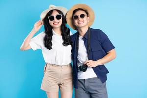 Asian couple traveling image  isolated on blue background photo