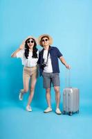 Asian couple traveling image  isolated on blue background photo