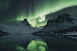 Aurora borealis on the Norway. Green northern lights above mountains. Night sky with polar lights. Night winter landscape with aurora photo