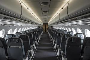 Interior of an airplane cabin with comfortable seats, overhead compartments photo