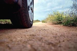 Car wheel on the road, low angle shot, road trip and adventuring photo