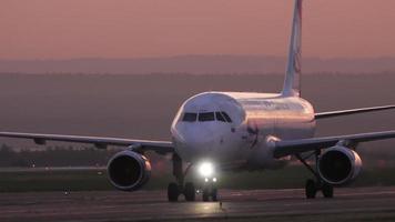 KAZAN, RUSSIA AUGUST 05, 2022 - Cinematic footage of a Ural Airlines passenger plane taxiing on the runway, sunset or dawn. Airplane on the taxiway at sunrise video