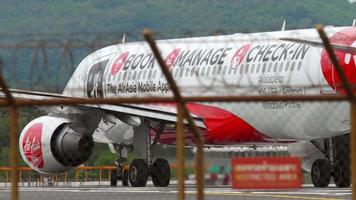 phuket, Thailand november 26, 2017 - luchtazië luchtbus a320 met mobiel app kleurstelling boek, beheren, controleren in Aan de landingsbaan Bij phuket luchthaven. toerisme en reizen concept video