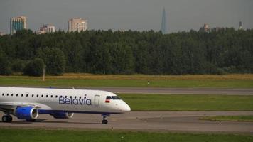 SAINT PETERSBURG, RUSSIA JULY 26, 2022 - Embraer E195LR, EW 513PO of Belavia taxiing on the taxiway at Pulkovo airport, side view. Belavia Belarusian airline. Tourism and travel concept video