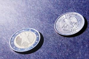 Two coins euro and ruble on dark background in sunlight, heads and tails photo