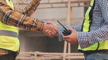 Two business man construction site engineer. Engineering objects on workplace with partners interacting on background video