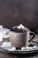 Chocolate cake in a mug with marshmallows and powdered sugar for homemade dessert vertical view photo