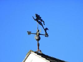 Mermaid weather vane against a blue sky photo