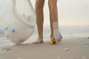 ahorrar agua. los voluntarios recogen basura en la playa y las botellas de plástico son difíciles de descomponer para evitar dañar la vida acuática. tierra, ambiente, planeta verde, reducir el calentamiento global, salvar el mundo foto