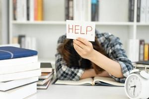 Asian student woman have anxiety because of exams, female prepare for test and learning lessons in the library. stress, despair, haste, misunderstanding reading, discouraged, expectation, knowledge photo