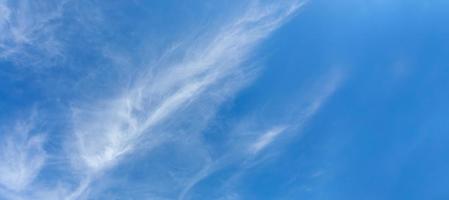 Natural white cirrus clouds as feathers are diagonally on blue sky. Skyscape. Banner. Copy space. photo