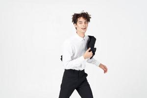 handsome young man in classic suit with jacket in hand on light background cropped view photo