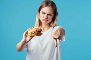 mujer con hamburguesa rápido comida entrega bocadillo divertido azul antecedentes foto