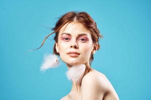 pretty woman fluffy earrings bright makeup blue background fashion photo