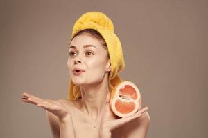 Woman with a towel on her head grapefruit in her hands health vitamins bared shoulders photo