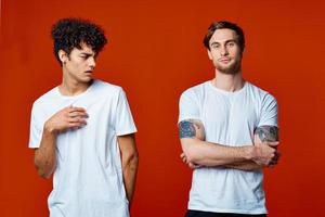 two men in white t-shirts on a red background friendship photo