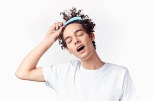 curly guy stuck comb in his hair emotions light background photo