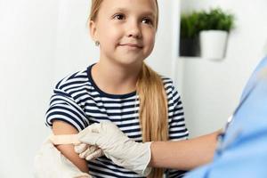 the doctor seals the hand of the child with a plaster close-up photo