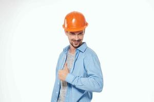 man in orange hard hat construction safety work light background photo
