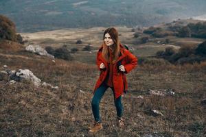 woman in a jacket with a backpack mountains steppe landscape autumn warm clothes model photo