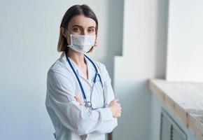 Woman doctor in a medical mask with a stethoscope around her neck photo