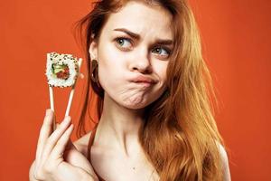 mujer con palillos Sushi rollos japonés cocina bocadillo foto