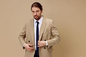 man in beige jacket in a suit with a tie posing isolated background photo