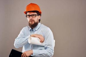 hombre en construcción uniforme naranja casco dibujos documentos trabajo servicios foto