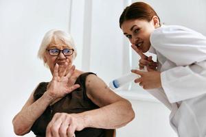 an elderly woman at a doctor's appointment a large syringe immunity protection photo