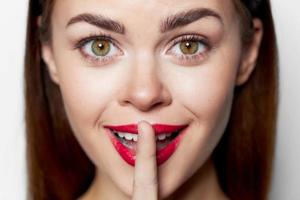 Close-up portrait of woman holding finger near lips photo