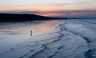 Sunset Sky with clouds over sea sand beach with ocean wave in evening Summer,Landscape by Seaside with Colourful Sky in Orange,Pink,Purple,Blue.Beautiful Horizontal Sunlight reflection on sandy beach photo