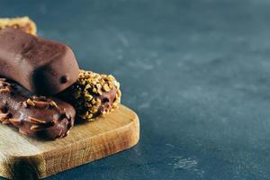 Eskimo ice cream in chocolate glaze on blue background. Yummy sweet food snack treat. Copy space photo