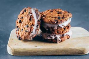 Chocolate Ice cream sandwiches and chocolate chip cookies on wooden board photo