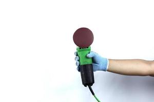 Gloved hand holding  angle grinder machine isolated on white background photo