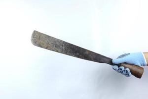 Gloved hand holding machete isolated on white background photo