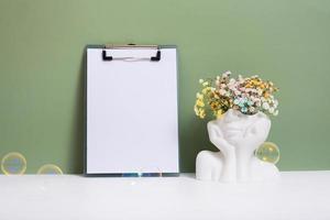 Message board mockup with creative plaster head vase with flowers. Mental health concept copy space photo