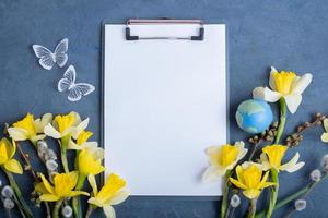 Empty text board with flowers, globe and butterflies top view, flat lay. Earth day mockup photo