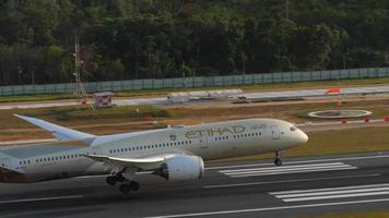 PHUKET, THAILAND FEBRUARY 11, 2023 - Airplane Boeing 787 Dreamliner of Etihad Airways landing and touching at Phuket airport, side view. Jet modern aircraft arrive. Tourism and travel concept video