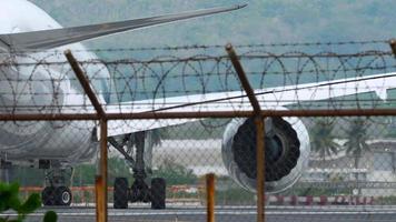 PHUKET, THAILAND JANUARY 31, 2023 - Plane rides on runway. Stock footage. Plane is preparing for takeoff moving along runway in winter. Plane on runway before flying abroad for vacation. video