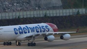 phuket, Thailand februari 23, 2023 - passagier Jet vliegtuig luchtbus a340, hb jme van edelweiss lucht taxiën Bij phuket luchthaven. kleppen omhoog. passagiersvliegtuig Aan de landingsbaan of Aan de taxi weg video