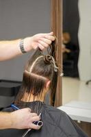 Male hairdresser splits long hair photo