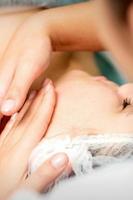 Young woman receiving facial massage photo