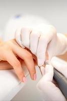 Manicurist removing old nail polish photo