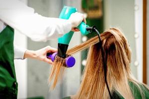 Young woman receiving drying hair photo