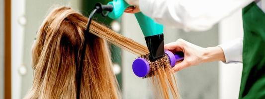 Young woman receiving drying hair photo