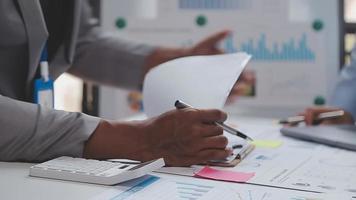 Financial analysts analyze business financial reports on a digital tablet planning investment project during a discussion at a meeting of corporate showing the results of their successful teamwork. video
