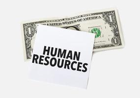 1 dollar bill and white notepad sheet on the white background. Text human resources photo