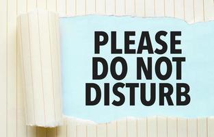 torn paper with text please do not disturb and blue background photo